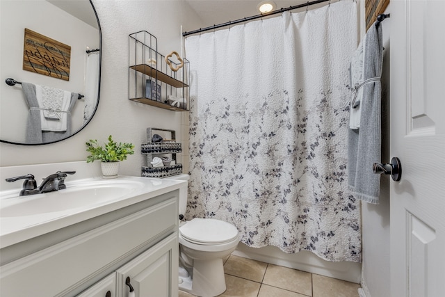 bathroom with tile patterned flooring, vanity, toilet, and walk in shower