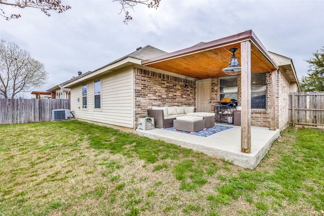 back of property featuring a lawn, an outdoor living space, cooling unit, and a patio area