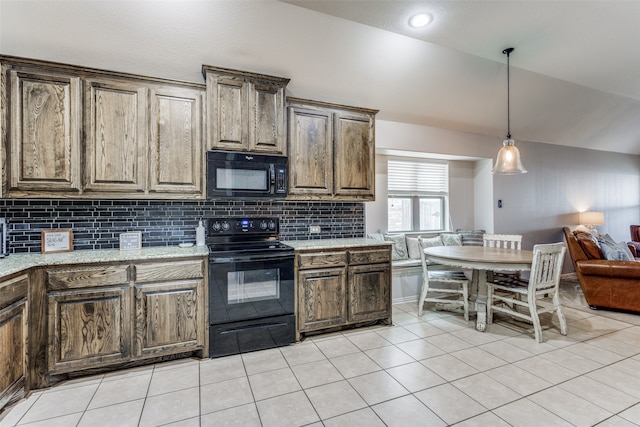 kitchen with light stone countertops, tasteful backsplash, black appliances, light tile patterned floors, and decorative light fixtures