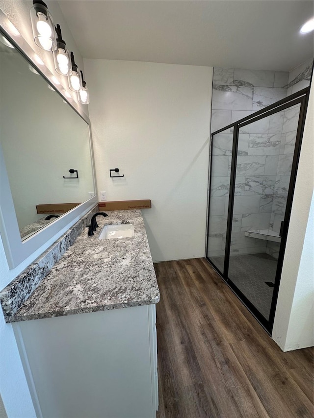 bathroom featuring hardwood / wood-style floors, vanity, and an enclosed shower