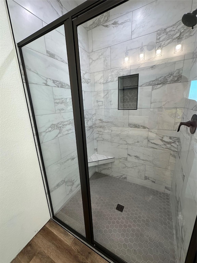 bathroom with hardwood / wood-style flooring and an enclosed shower