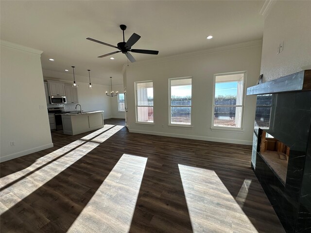 living room with crown molding, sink, dark wood-type flooring, and ceiling fan with notable chandelier