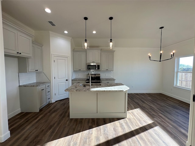 kitchen with decorative backsplash, appliances with stainless steel finishes, hanging light fixtures, and sink