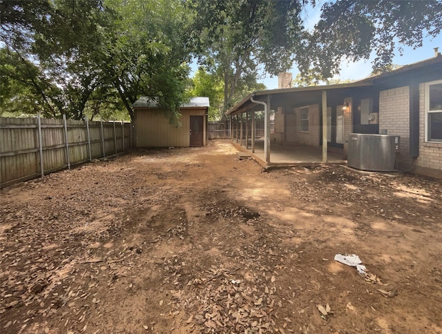 view of yard with a storage shed, a patio area, and cooling unit