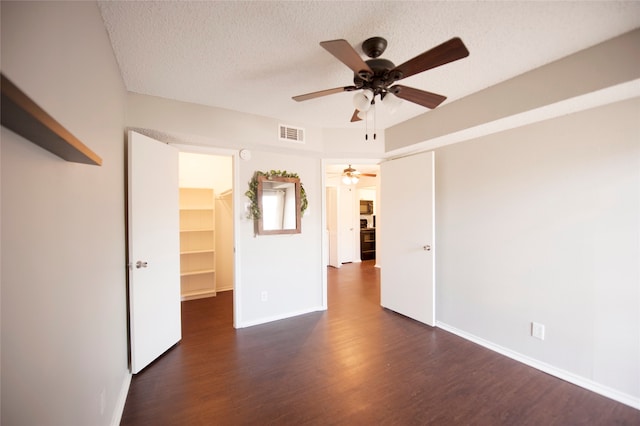 unfurnished room with dark hardwood / wood-style floors, a textured ceiling, and ceiling fan