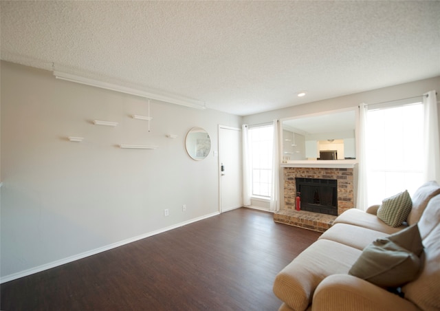 living room with a fireplace, a textured ceiling, and dark hardwood / wood-style flooring