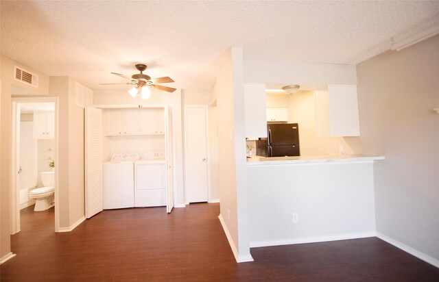 kitchen featuring hardwood / wood-style flooring, ceiling fan, white cabinets, black fridge, and a textured ceiling