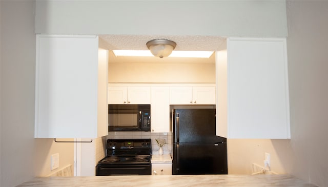 kitchen with decorative backsplash, white cabinetry, and black appliances