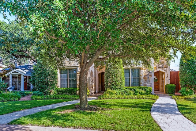 view of property hidden behind natural elements with a front yard