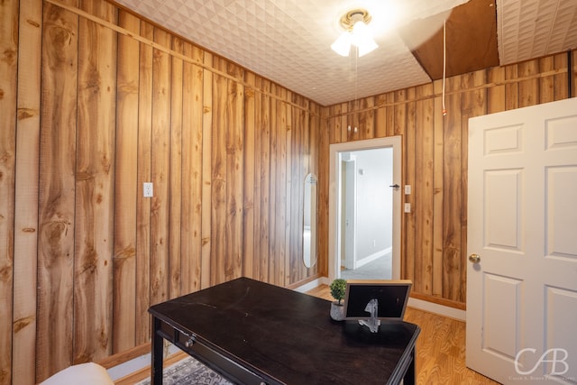 office area with hardwood / wood-style flooring and wooden walls