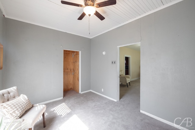 living area with ornamental molding, light colored carpet, and ceiling fan