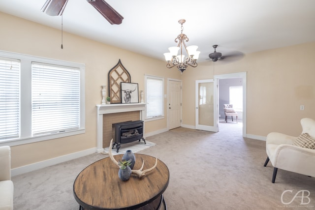 living room featuring a wood stove, plenty of natural light, and light colored carpet