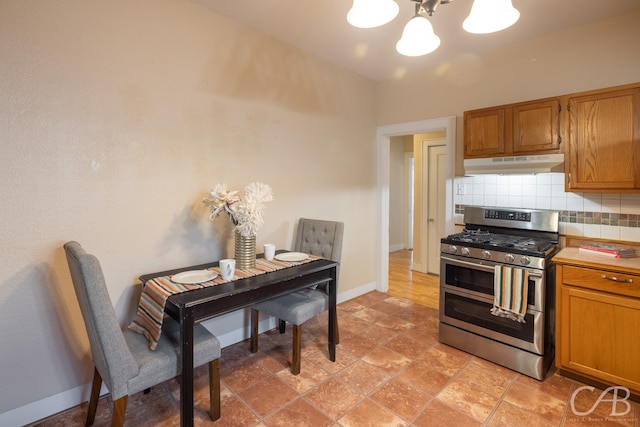 kitchen with range with two ovens, an inviting chandelier, and tasteful backsplash