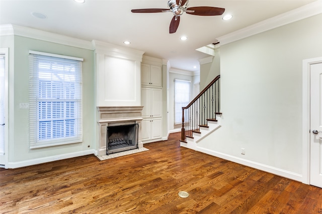 unfurnished living room featuring hardwood / wood-style flooring, crown molding, and ceiling fan