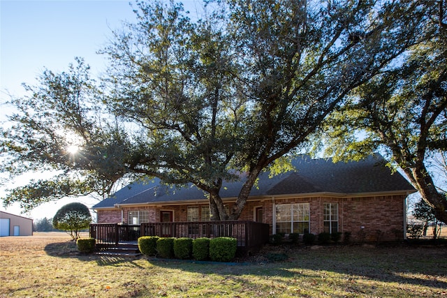 rear view of house with a wooden deck and a yard