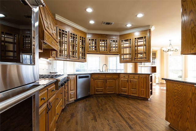 kitchen featuring dark hardwood / wood-style flooring, a notable chandelier, stainless steel appliances, sink, and kitchen peninsula