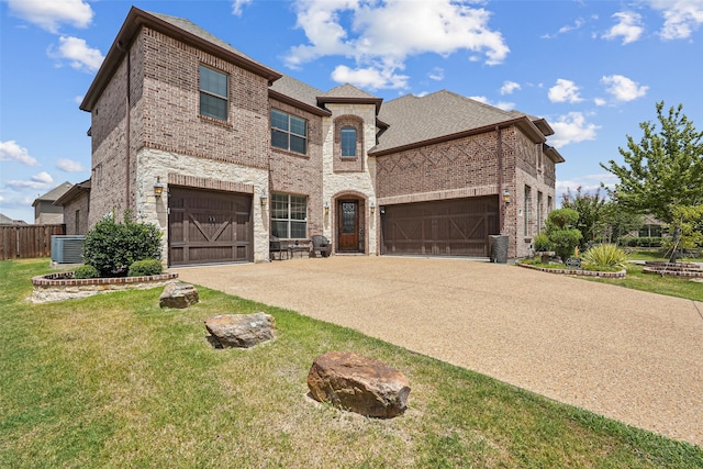 view of front of house featuring a garage, central air condition unit, and a front lawn