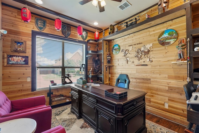 office area with wooden walls, hardwood / wood-style floors, and ceiling fan