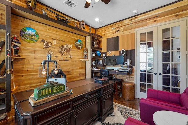 home office with french doors, ceiling fan, hardwood / wood-style flooring, and wooden walls