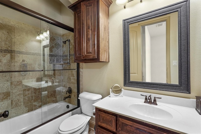 full bathroom featuring vanity, shower / bath combination with glass door, and toilet