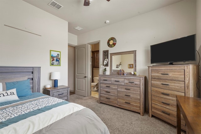 carpeted bedroom with ensuite bath and ceiling fan