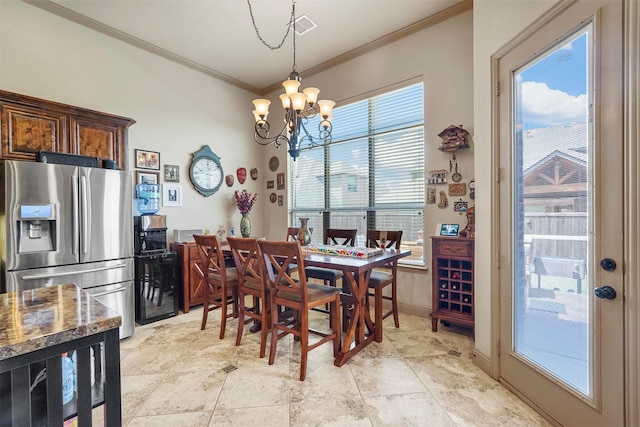 dining area with crown molding, a notable chandelier, and light tile patterned floors