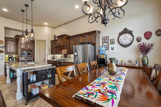 tiled dining area featuring an inviting chandelier, sink, and ornamental molding