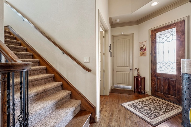 foyer entrance featuring crown molding and wood-type flooring