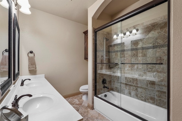 full bathroom featuring double vanity, combined bath / shower with glass door, tile patterned floors, and toilet