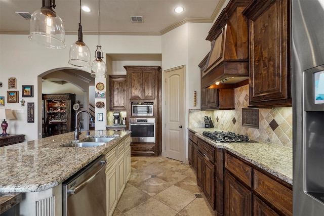 kitchen with tasteful backsplash, a kitchen island with sink, stainless steel appliances, custom exhaust hood, and sink