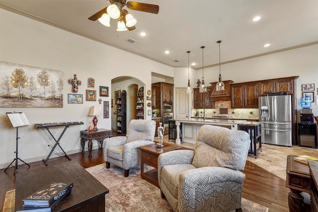 living room with ceiling fan, sink, crown molding, and hardwood / wood-style floors