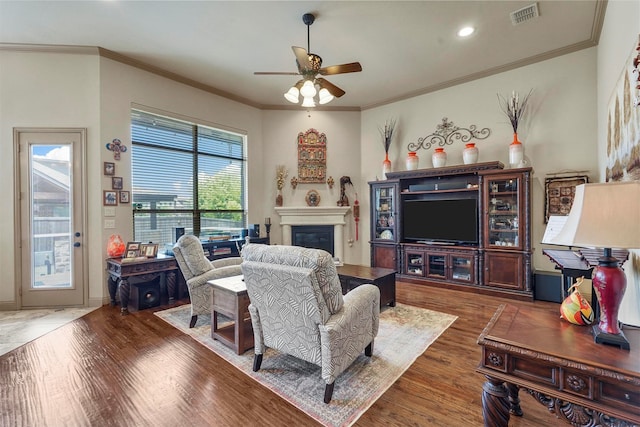 living room with ornamental molding, ceiling fan, and hardwood / wood-style floors