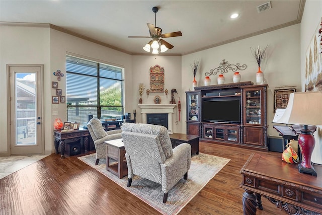 living room featuring ceiling fan, dark hardwood / wood-style flooring, and ornamental molding