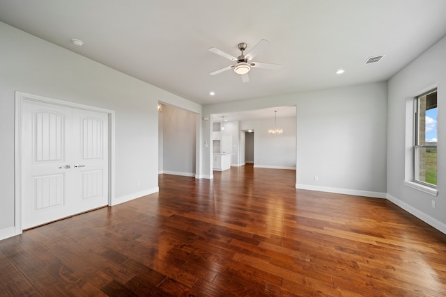 interior space featuring dark hardwood / wood-style flooring and ceiling fan with notable chandelier