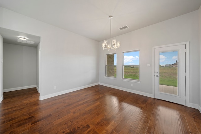 unfurnished dining area with a notable chandelier and dark hardwood / wood-style floors