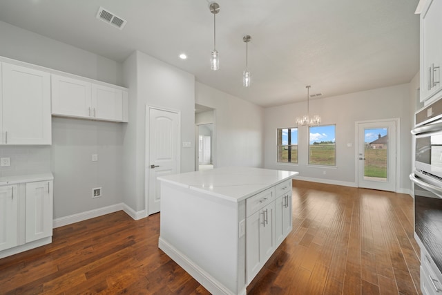 kitchen featuring a kitchen island, white cabinetry, pendant lighting, and dark hardwood / wood-style flooring