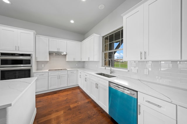 kitchen featuring appliances with stainless steel finishes, sink, white cabinetry, light stone counters, and dark hardwood / wood-style floors