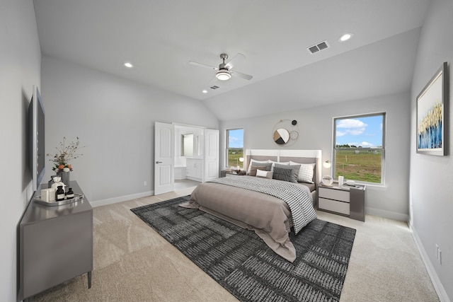 carpeted bedroom with ensuite bath, vaulted ceiling, multiple windows, and ceiling fan