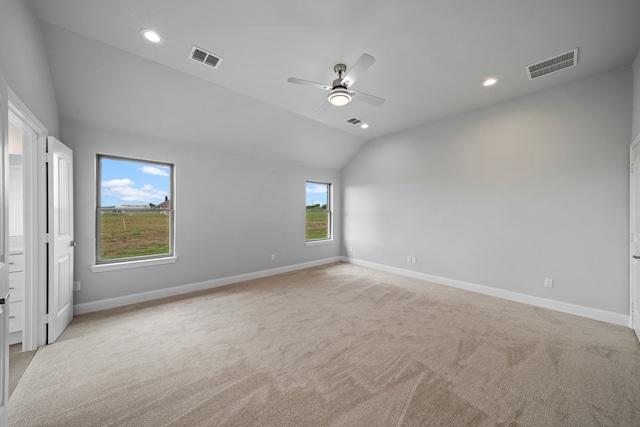 carpeted spare room featuring lofted ceiling and ceiling fan