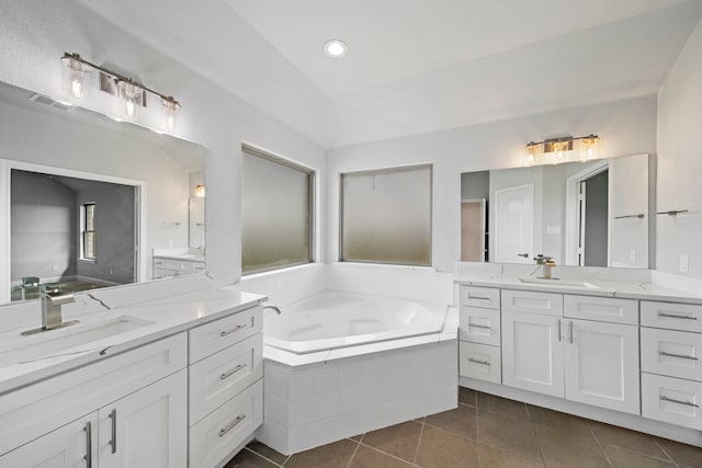 bathroom with vanity, tiled tub, and tile patterned flooring