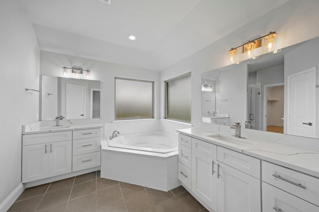 bathroom with vanity, tile patterned flooring, and tiled bath