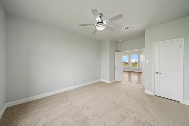 carpeted spare room with ceiling fan