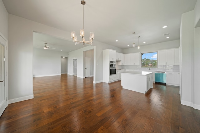 kitchen featuring dark hardwood / wood-style floors, a center island, white cabinets, pendant lighting, and appliances with stainless steel finishes