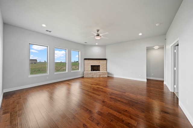 unfurnished living room with a fireplace, dark hardwood / wood-style floors, and ceiling fan