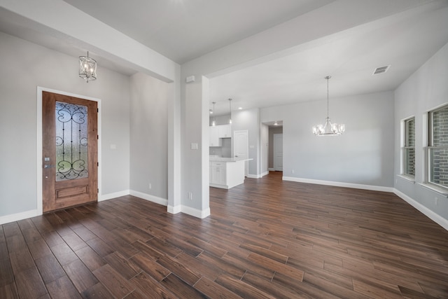 foyer entrance featuring a chandelier and dark hardwood / wood-style floors