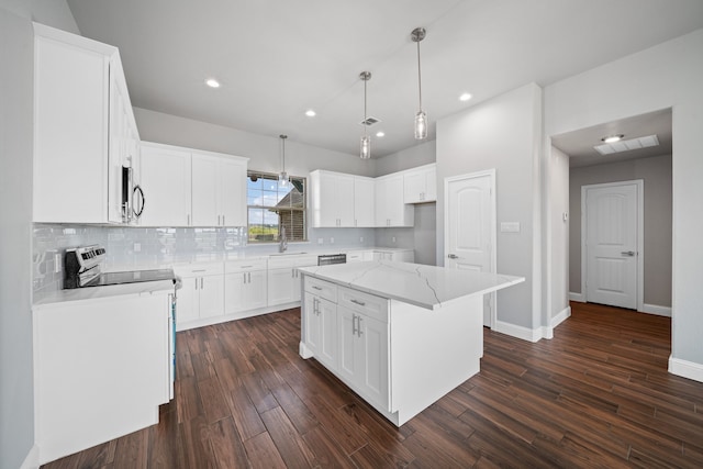 kitchen with white cabinetry, appliances with stainless steel finishes, a center island, and dark hardwood / wood-style floors