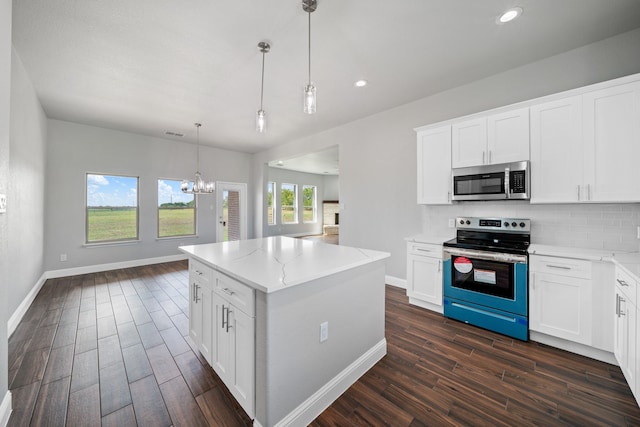 kitchen featuring white cabinets, hanging light fixtures, stainless steel appliances, and dark hardwood / wood-style floors