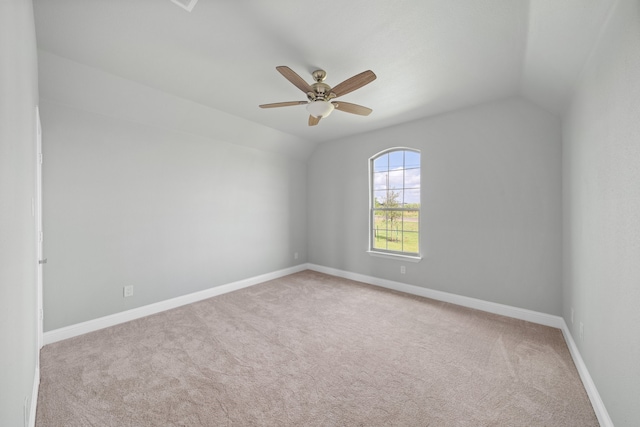 empty room featuring ceiling fan, lofted ceiling, and light colored carpet