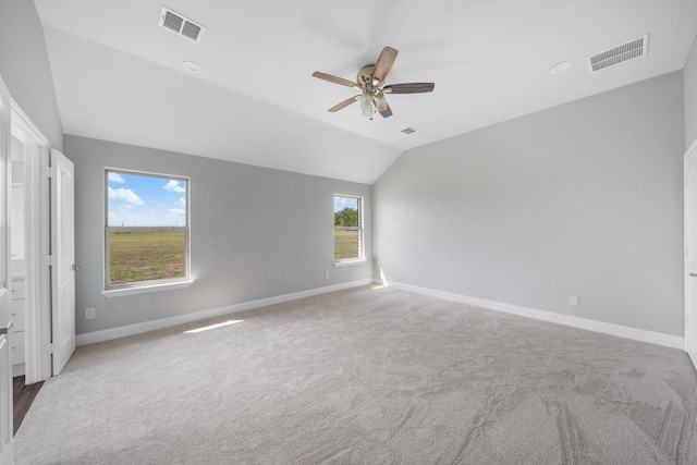 unfurnished room with vaulted ceiling, carpet floors, a healthy amount of sunlight, and ceiling fan