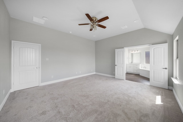 unfurnished bedroom with lofted ceiling, connected bathroom, carpet, and ceiling fan